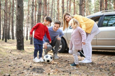 Genç çift küçük çocukları çam ormanı içinde futbol oynamak
