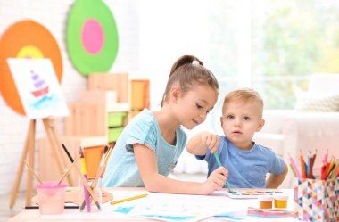 Küçük çocuklar masada kapalı çizim