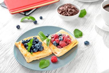 Ahşap masa üzerinde nefis berry puf böreği ile plaka