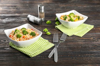 Ahşap masa üzerinde kase brokoli ile lezzetli pirinç pilavı