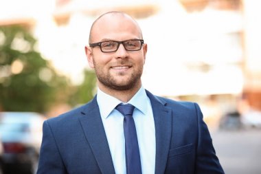 Arka plan bulanık üzerinde takım elbiseli genç adam