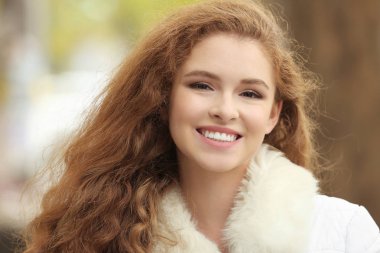 Açık havada faux kürk yakalı ceketli güzel gülümseyen kadın