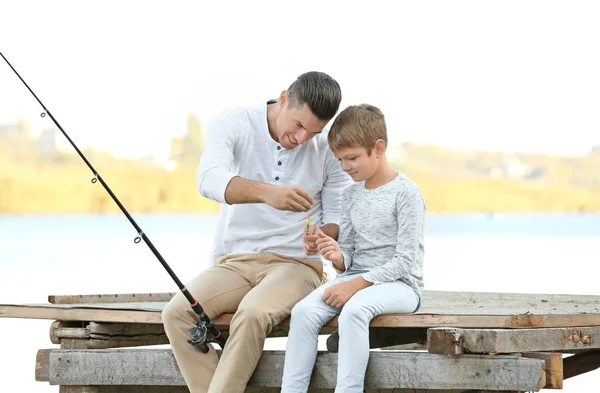 Otec a jeho syn loví z mola na řece — Stock fotografie