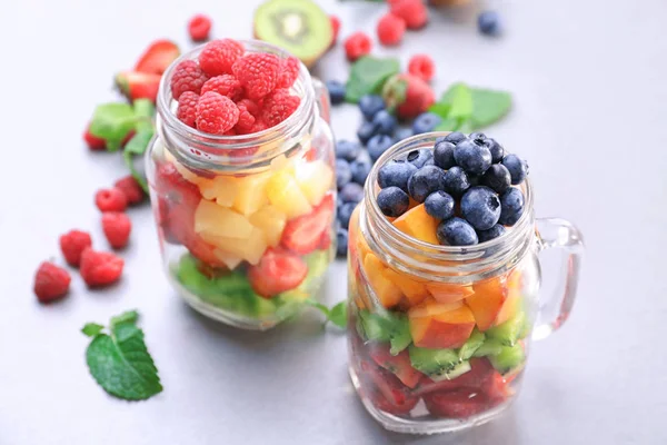 Frascos Mason con frutas y bayas en la mesa —  Fotos de Stock