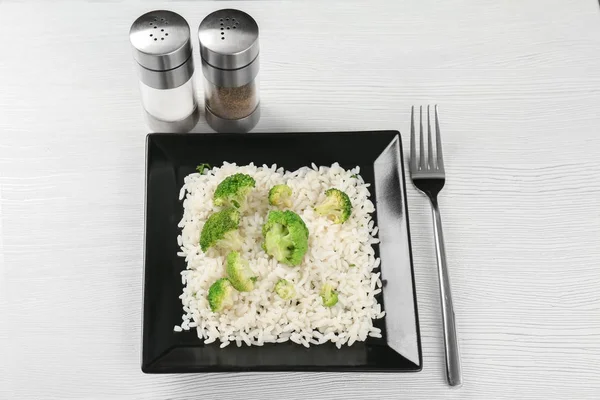 Deska s rýží a brokolicí na bílý dřevěný stůl — Stock fotografie