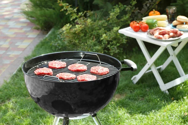 Barbecue grill avec de savoureux galettes sur la cour — Photo