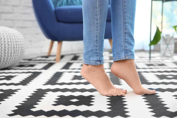 Жінка стоїть на килимі вдома — стокове фото