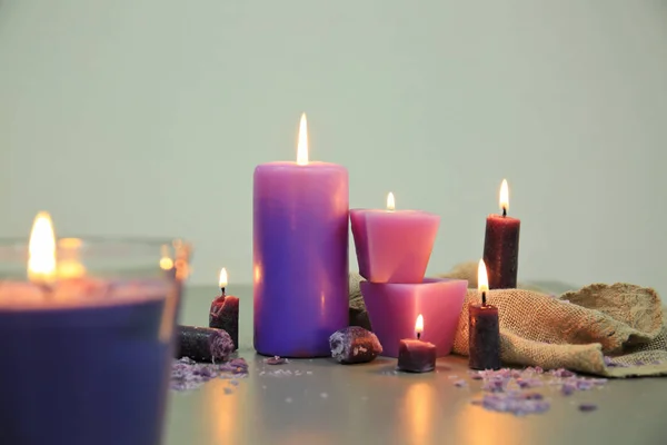 Velas ardientes púrpura en la mesa — Foto de Stock