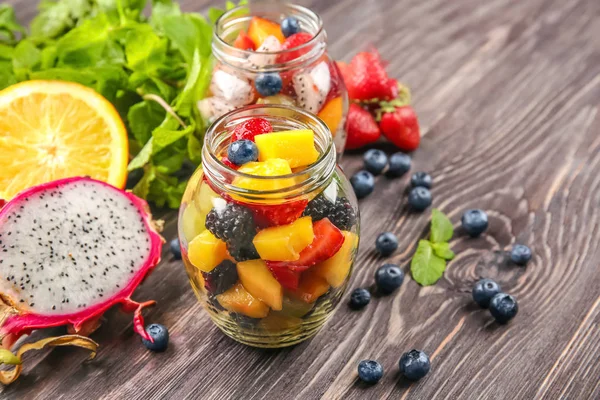 Glas mit köstlichem Obstsalat auf Holztisch — Stockfoto