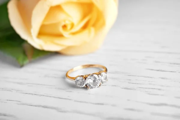 Beautiful engagement ring on wooden background — Stock Photo, Image