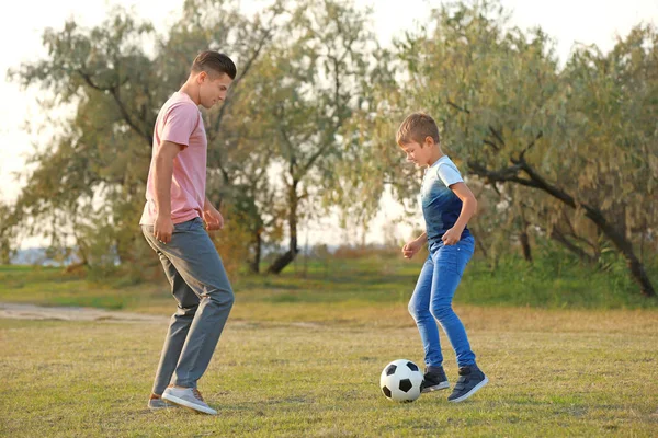 Baba ve oğlu kırsalında futbol oynamak