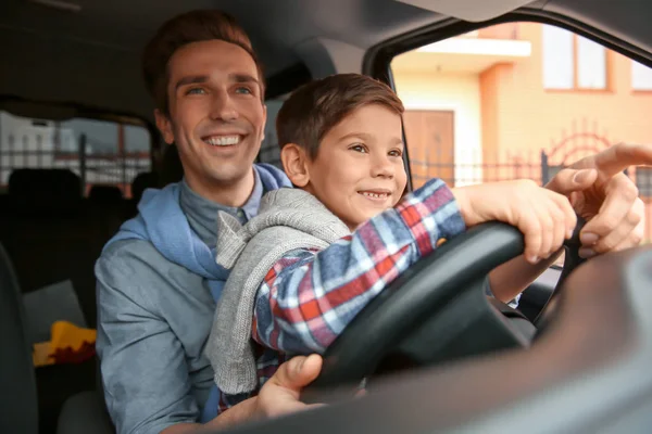 Père apprenant à son petit fils à conduire une voiture — Photo