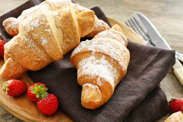 Placa con sabrosos croissants y fresas — Foto de Stock