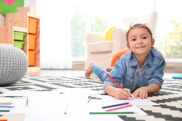 Liten flicka ritning på golvet hemma — Stockfoto