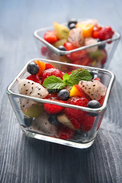 Cuencos de postre con deliciosa ensalada de frutas en mesa de madera — Foto de Stock