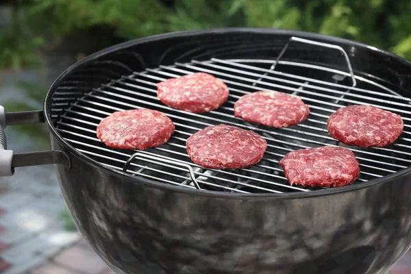 Barbecue grill met smakelijke pasteitjes op achtertuin — Stockfoto
