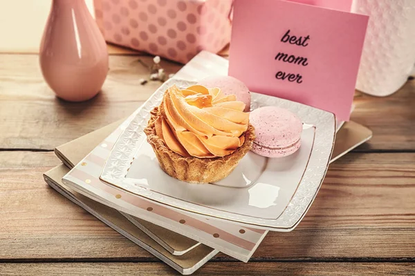 Deliziosi dolci e biglietto di auguri con le parole "Miglior mamma di sempre" sul tavolo di legno — Foto Stock