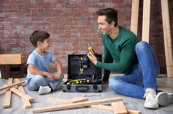 Father showing his little son different tools in workshop — Stock Photo, Image