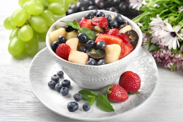 Cuenco con deliciosa ensalada de frutas en mesa de madera — Foto de Stock