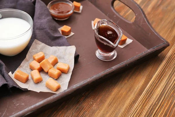 Komposition mit leckeren Bonbons und Karamellsoße auf dem Tisch — Stockfoto