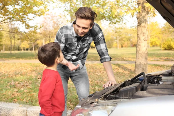 야외에서 차를 수리 하는 귀여운 소년과 젊은 아버지 — 스톡 사진