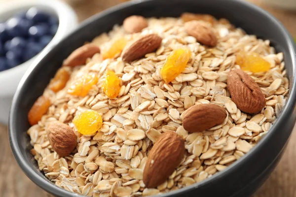 Bowl with oatmeal flakes, raisins and almond, closeup — Stock Photo, Image