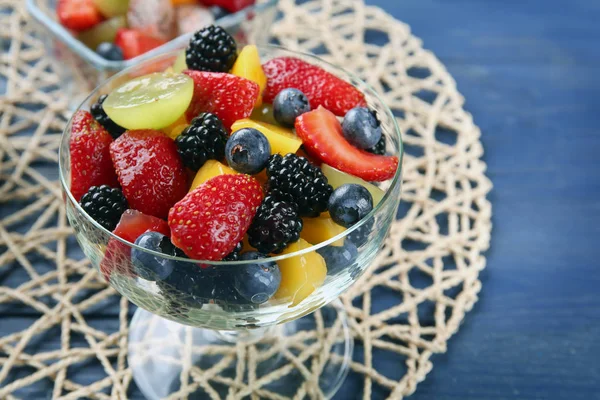Tigela de sobremesa com deliciosa salada de frutas na mesa de madeira — Fotografia de Stock
