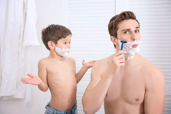 Pai e seu filho fazendo a barba no banheiro — Fotografia de Stock