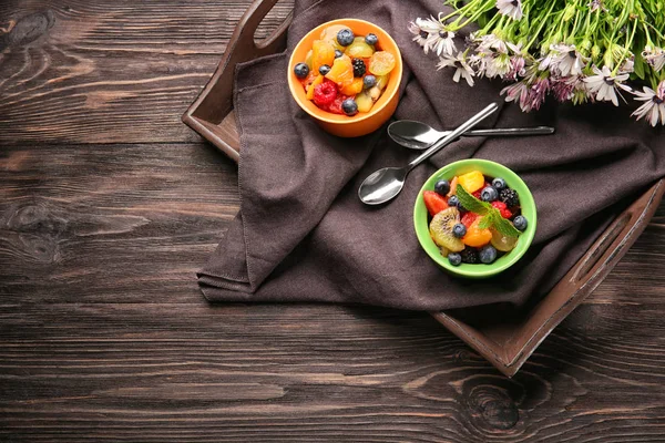 Gerechten met heerlijke fruitsalade op dienblad — Stockfoto