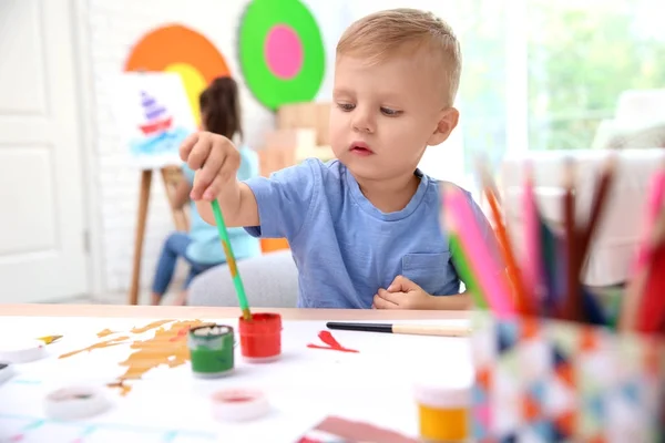 Little boy and blurred girl painting indoors — Stock Photo, Image