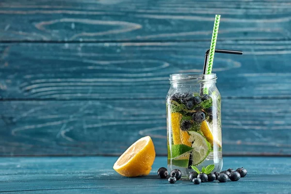 Mason jar infunderas vatten med frukter på träbord — Stockfoto