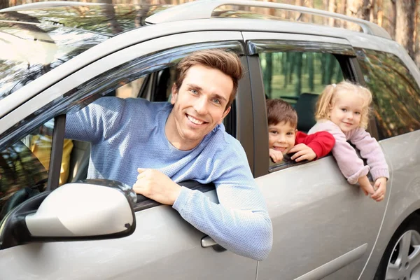 Happy man with his little children in car on sunny day — Stock Photo, Image