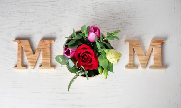 Wort "Mama" und frische Blumen auf hellem Hintergrund. Muttertagskomposition — Stockfoto