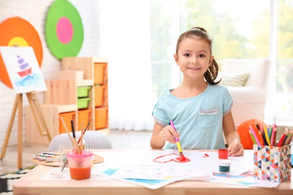 Menina pintando à mesa dentro de casa — Fotografia de Stock