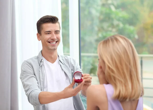 Homem com anel de noivado fazendo proposta de casamento com mulher em casa — Fotografia de Stock