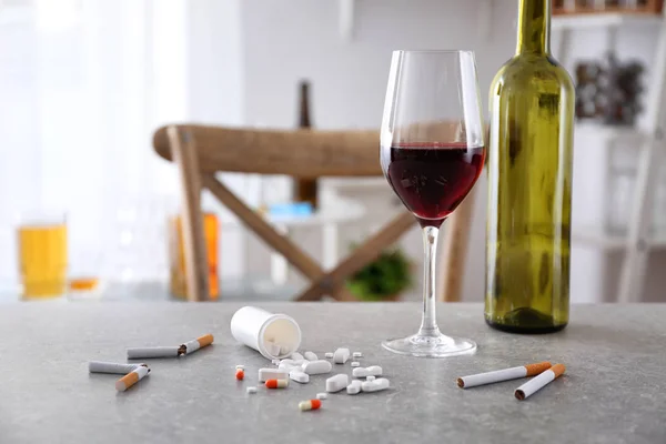 Glass of alcohol, cigarettes and drugs on table. Concept of bad habits — Stock Photo, Image