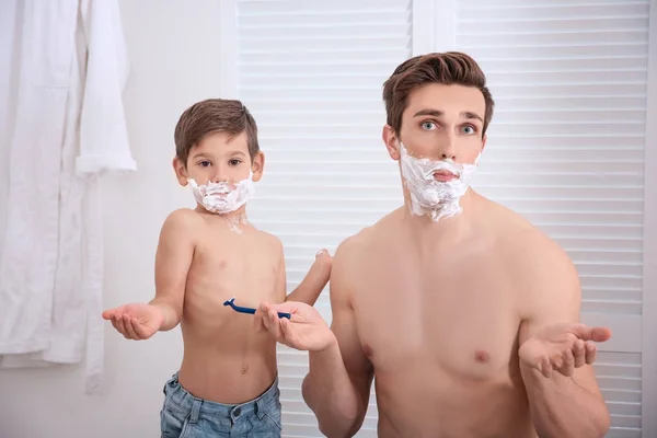 Отец и его маленький сын бреются в ванной — стоковое фото