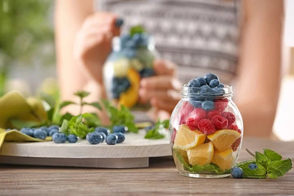 Jar with fruits and berries on table — Stock Photo, Image