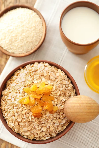 Mangkuk dengan serpih oatmeal dan kismis pada kain — Stok Foto