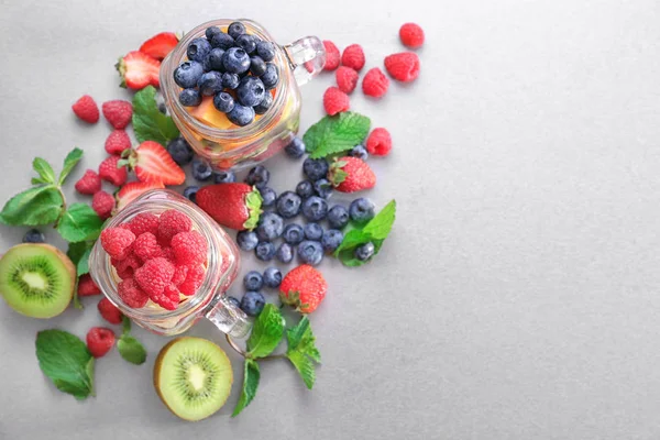 Frascos Mason con frutas y bayas en la mesa — Foto de Stock