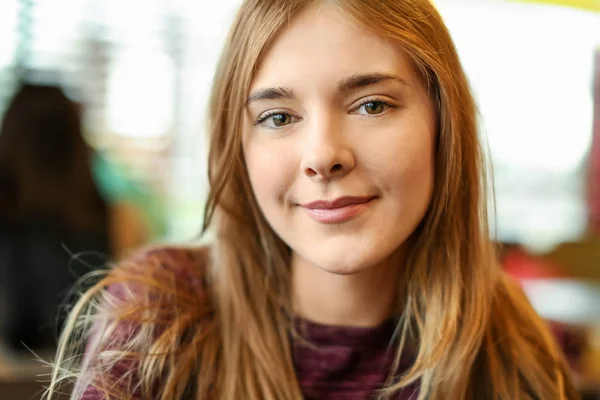 Портрет красивой улыбающейся молодой женщины в кафе — стоковое фото