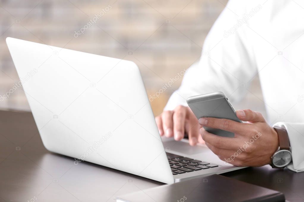 manager using laptop and phone