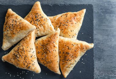Kayrak plakalı gri arka plan üzerinde lezzetli samosas