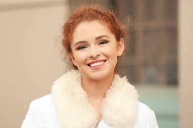 Açık havada faux kürk yakalı ceketli güzel gülümseyen kadın