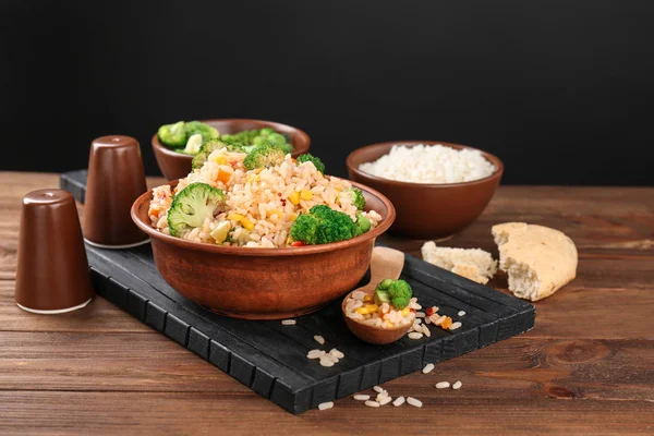 Delicious rice pilaf with broccoli in bowl on wooden table — Stock Photo, Image