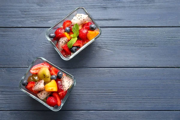 Boliches de sobremesa com deliciosa salada de frutas na mesa de madeira — Fotografia de Stock