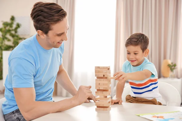 Pai e filho brincando com blocos de madeira em casa — Fotografia de Stock