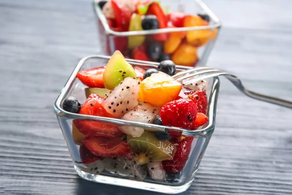 Десертні миски зі смачним фруктовим салатом на дерев'яному столі — стокове фото