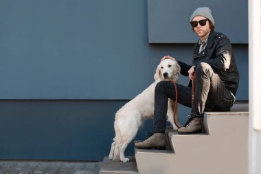 Açık havada köpekli yakışıklı genç yenilikçi