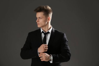 Gri arka plan üzerinde resmi kıyafetli yakışıklı adam